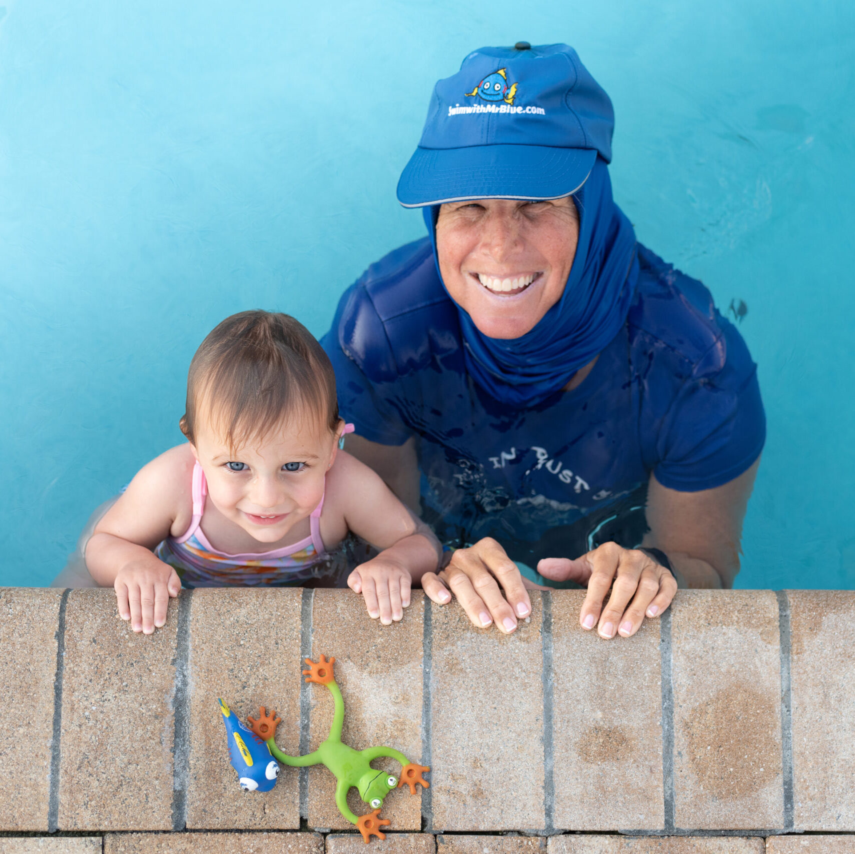 Coach Julie and student learning to choo choo along the wall with Popo and Mr. Blue